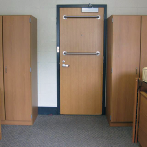 Wardrobes on either side of a door, beds in foreground