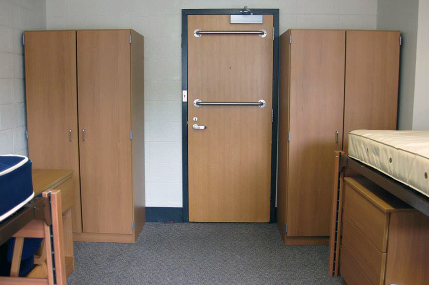 Wardrobes on either side of a door, beds in foreground