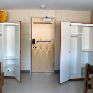Open wardrobes on either side of a door, beds in foreground
