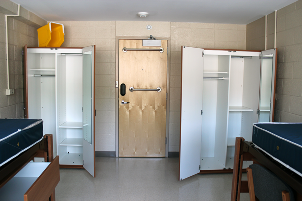 Open wardrobes on either side of a door, beds in foreground