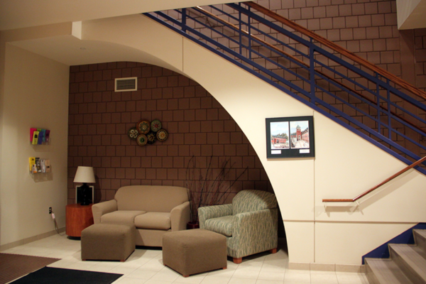 Entrance room with arm chair and sofa beneath the staircase