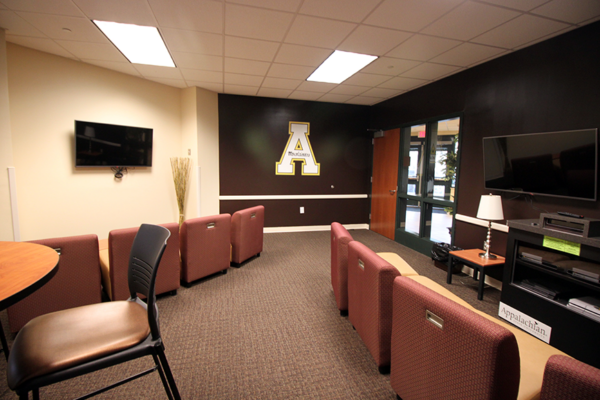 Entertainment room with multiple TVs and seats