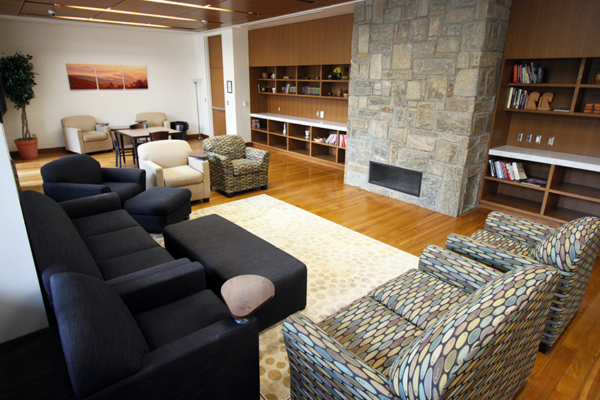 Armchairs and sofas around a fireplace with a bookshelf